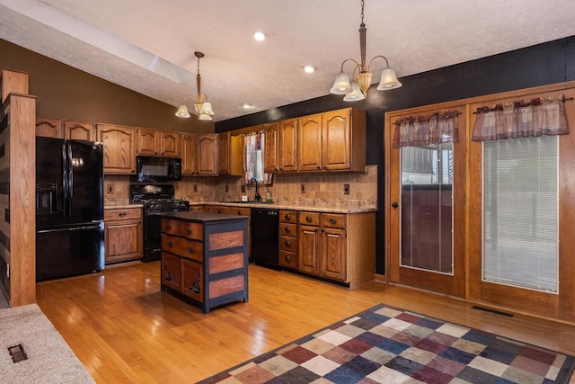 1413 Bethany Ln, Pontiac, IL 61764 - kitchen with black appliances, a chandelier, light wood-type flooring, tasteful backsplash, and lofted ceiling