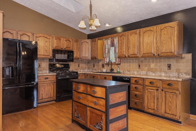 1413 Bethany Ln, Pontiac, IL 61764 - kitchen with black appliances, lofted ceiling, a chandelier, light wood finished floors, and brown cabinets