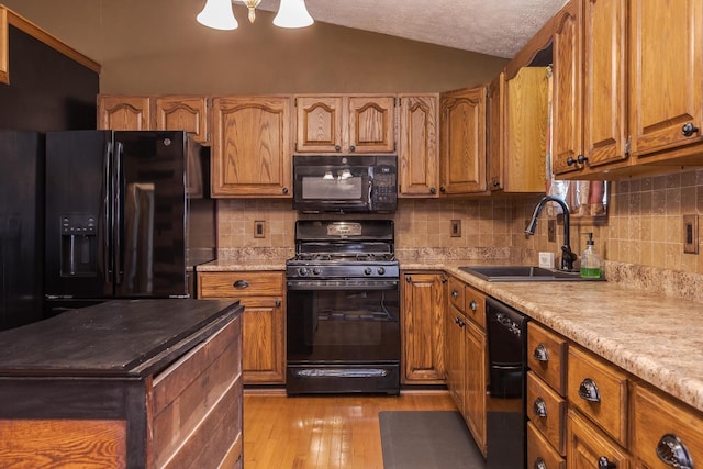 1413 Bethany Ln, Pontiac, IL 61764 - kitchen with black appliances, brown cabinets, light wood-style floors, and lofted ceiling