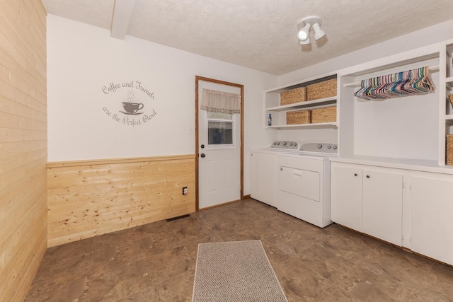 1413 Bethany Ln, Pontiac, IL 61764 - laundry room featuring wooden walls, washer and dryer, stone finish flooring, cabinet space, and a textured ceiling
