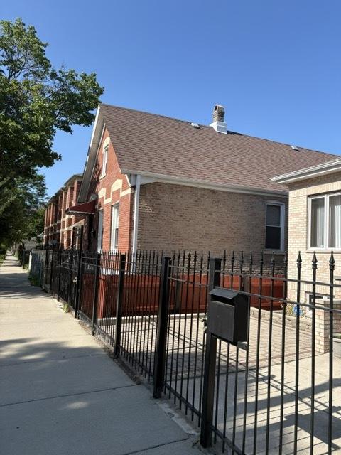 3417 S Morgan St, Chicago, IL 60608 - view of side of home featuring brick siding, roof with shingles, and a chimney