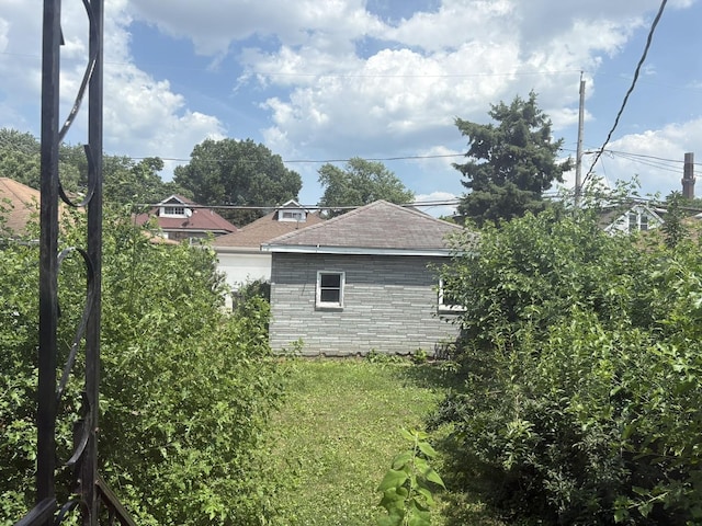 5535 S Fairfield Ave, Chicago, IL 60629 - view of side of property with a shingled roof and a yard