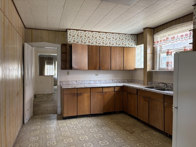 5535 S Fairfield Ave, Chicago, IL 60629 - kitchen featuring freestanding refrigerator, light countertops, backsplash, wood walls, and brown cabinetry