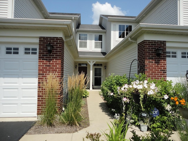 371 Mcgrath Dr, Oswego, IL 60543 - view of exterior entry with brick siding and an attached garage