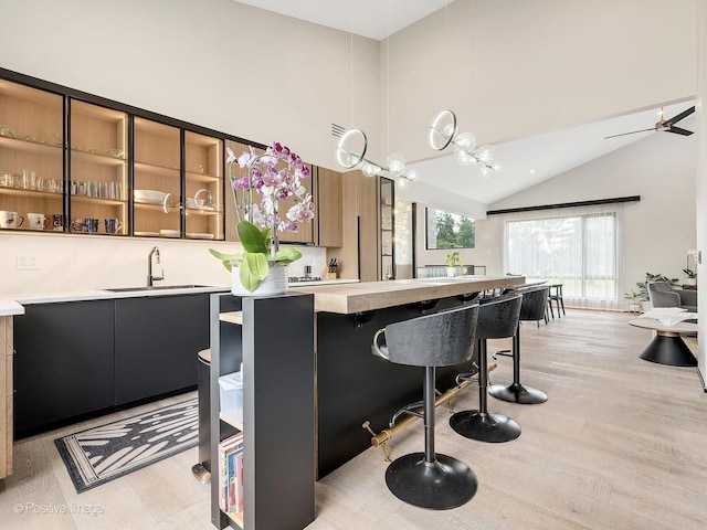 849 Cramer Ct, Willowbrook, IL 60527 - kitchen featuring light countertops, a kitchen bar, brown cabinetry, high vaulted ceiling, and hanging light fixtures