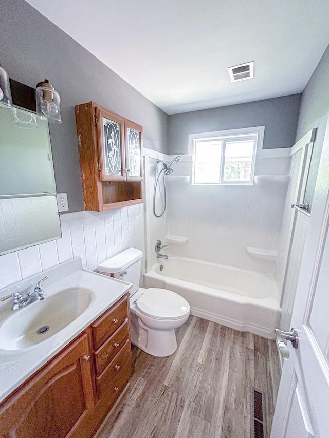425 W Donald St, Kankakee, IL 60901 - bathroom featuring wood finished floors, vanity, bathing tub / shower combination, tile walls, and backsplash