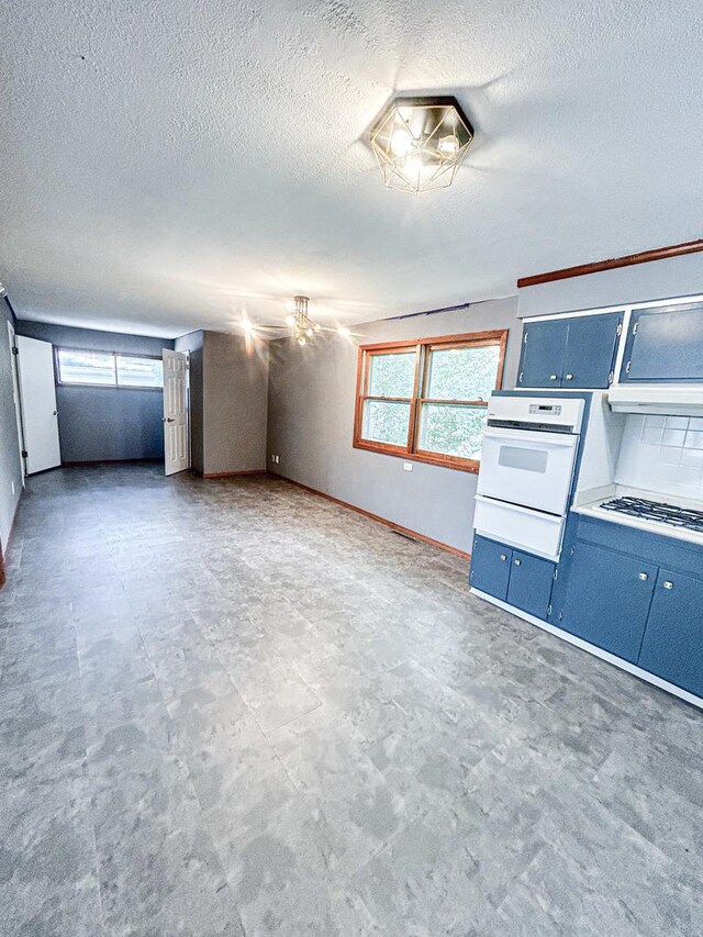 425 W Donald St, Kankakee, IL 60901 - unfurnished living room with a textured ceiling and baseboards