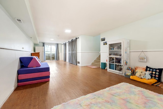 3S221 Sequoia Dr, Glen Ellyn, IL 60137 - bedroom with wood finished floors, a barn door, and a wainscoted wall