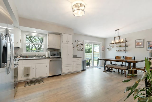 3S221 Sequoia Dr, Glen Ellyn, IL 60137 - kitchen with stainless steel appliances, dark countertops, light wood-style floors, white cabinets, and hanging light fixtures