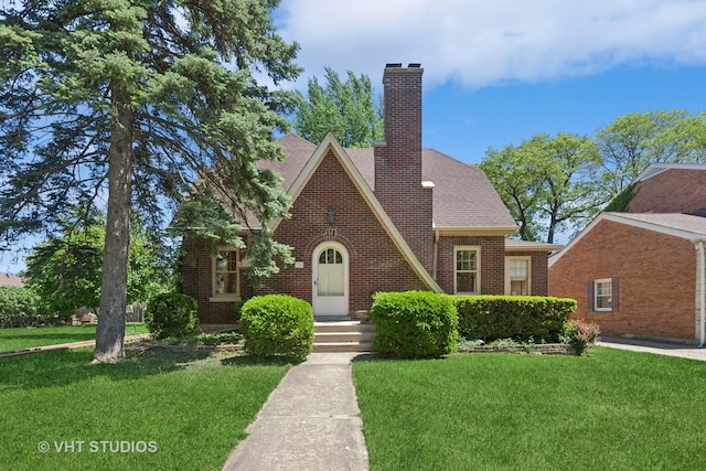 733 N Kensington Ave, La Grange Park, IL 60526 - tudor house featuring a front yard, brick siding, a chimney, and a shingled roof