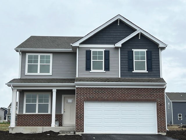 1907 Overland Dr, Plainfield, IL 60586 - view of front of property with covered porch, a garage, brick siding, and driveway