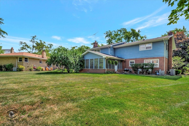 19126 Pierce Ave, Homewood, IL 60430 - rear view of house featuring a chimney, a sunroom, brick siding, and a lawn