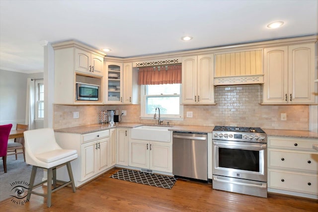 19126 Pierce Ave, Homewood, IL 60430 - kitchen featuring stainless steel appliances, crown molding, light stone counters, decorative backsplash, and glass insert cabinets