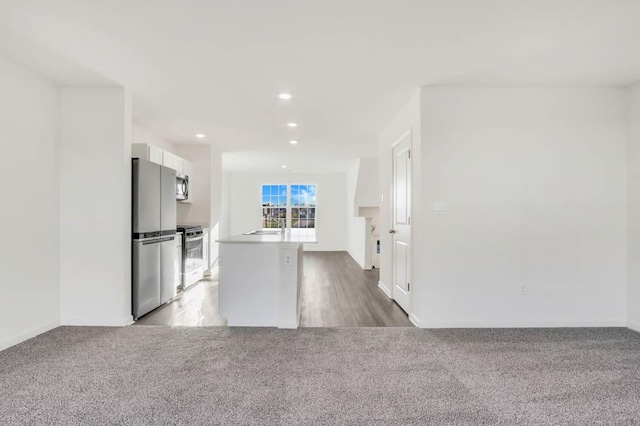 857 Briar Glen Ct, Hampshire, IL 60140 - kitchen with stainless steel appliances, carpet, white cabinets, recessed lighting, and an island with sink