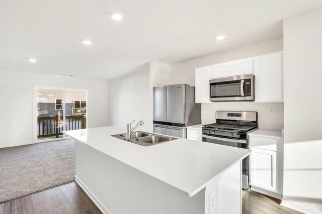 857 Briar Glen Ct, Hampshire, IL 60140 - kitchen featuring stainless steel appliances, light countertops, white cabinetry, a center island with sink, and wood finished floors