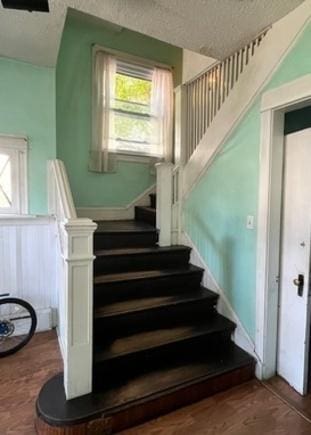 3651 W 64th Pl, Chicago, IL 60629 - stairway featuring a textured ceiling and wainscoting