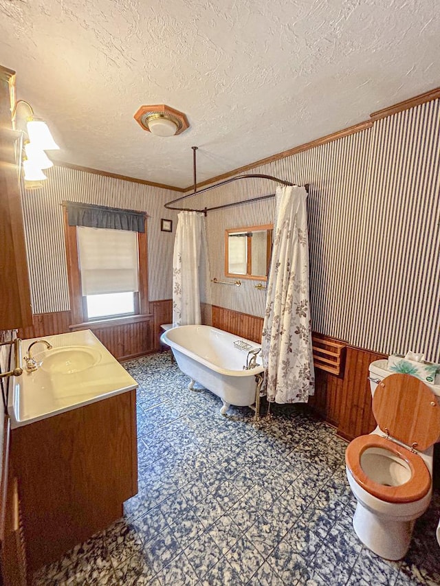997 S Evergreen Ave, Kankakee, IL 60901 - bathroom with a freestanding bath, crown molding, a textured ceiling, wooden walls, and tile patterned floors