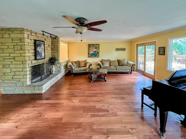 20798 White Oaks Rd, Morrison, IL 61270 - living area featuring ceiling fan, ornamental molding, wood finished floors, and a stone fireplace