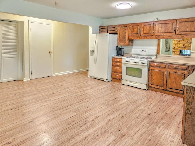20798 White Oaks Rd, Morrison, IL 61270 - kitchen with white appliances, brown cabinets, light wood-style floors, and light countertops