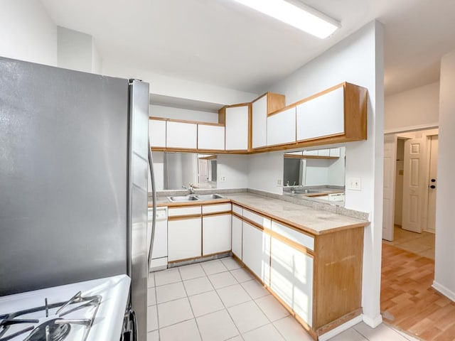 2458 N Clybourn Ave, Chicago, IL 60614 - kitchen featuring freestanding refrigerator, white dishwasher, white cabinetry, light countertops, and gas range