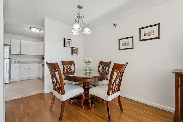 440 N Mcclurg Ct Unit 417, Chicago, IL 60611 - dining space featuring a textured ceiling, a chandelier, light wood-style floors, and ornamental molding