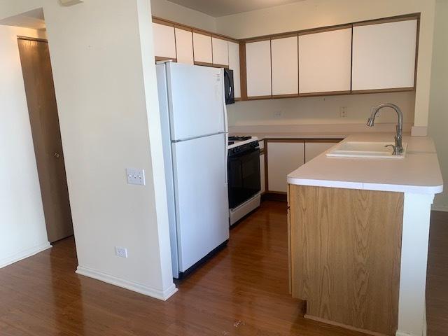2235 Dawson Ln, Algonquin, IL 60102 - kitchen with white appliances, dark wood finished floors, light countertops, and white cabinets