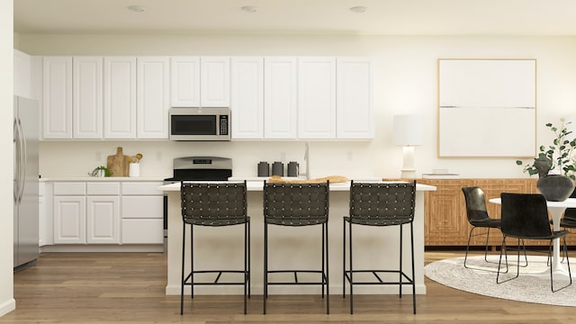 607 Wexford Dr, Elgin, IL 60124 - kitchen featuring appliances with stainless steel finishes, white cabinets, a kitchen breakfast bar, a kitchen island, and light wood finished floors
