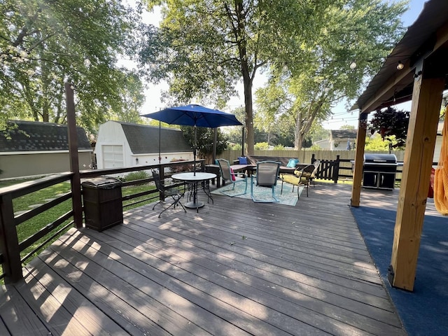 17 Park Dr, Villa Grove, IL 61956 - deck featuring grilling area, outdoor dining area, a storage unit, a fenced backyard, and an outdoor fire pit