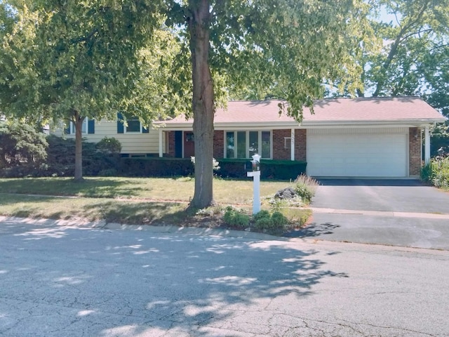 303 W St, Geneva, IL 60134 - view of front facade featuring driveway, an attached garage, brick siding, and a front lawn
