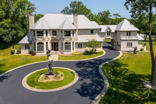 1130 Gavin Ct, Lake Forest, IL 60045 - view of front of home featuring stone siding, stucco siding, a chimney, curved driveway, and a balcony