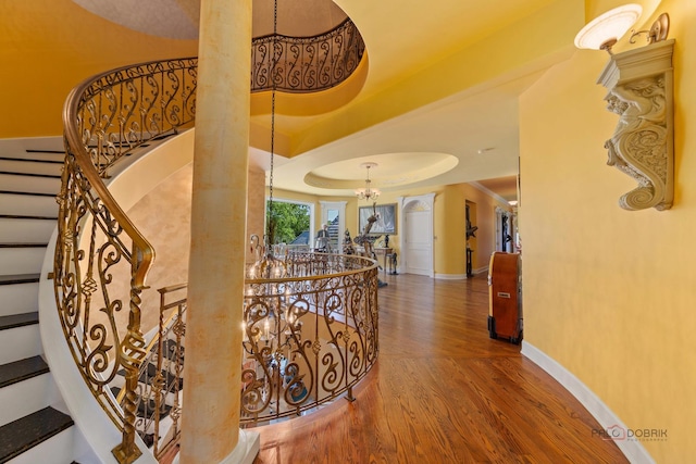 1130 Gavin Ct, Lake Forest, IL 60045 - hallway with wood finished floors, a chandelier, a tray ceiling, decorative columns, and stairway