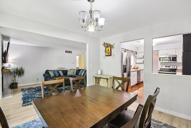 1521 S County Farm Rd Unit 2-2, Wheaton, IL 60189 - dining space featuring light wood-type flooring and a chandelier