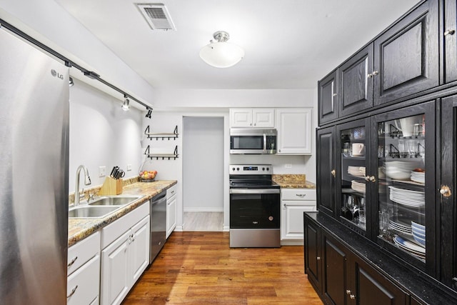 1521 S County Farm Rd Unit 2-2, Wheaton, IL 60189 - kitchen with stainless steel appliances, light wood-type flooring, white cabinetry, and a barn door
