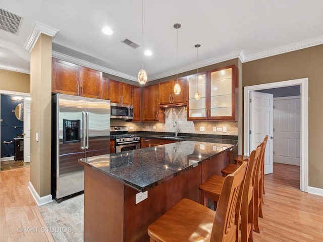 4553 N Magnolia Ave Unit 205, Chicago, IL 60640 - kitchen featuring appliances with stainless steel finishes, light wood-style flooring, tasteful backsplash, crown molding, and a kitchen breakfast bar