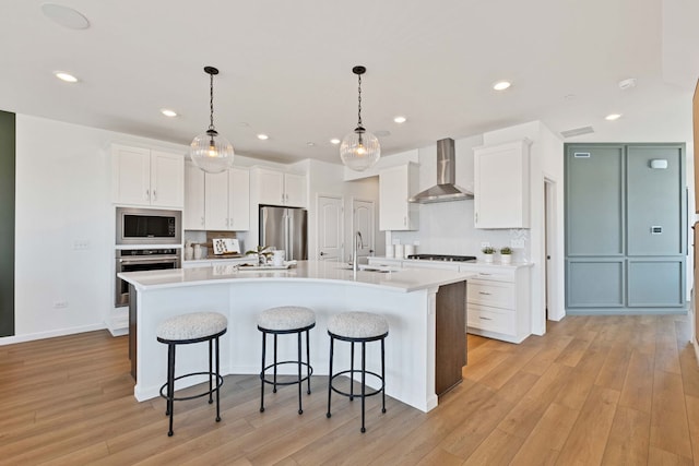 1063 Houston St Unit 89005, Batavia, IL 60510 - kitchen with wall chimney exhaust hood, stainless steel appliances, white cabinetry, light wood-style floors, and recessed lighting