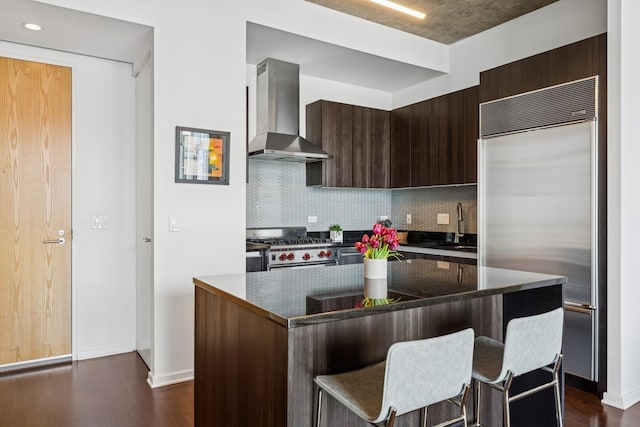 600 N Fairbanks Ct Unit 3304, Chicago, IL 60611 - kitchen featuring premium appliances, wall chimney range hood, a kitchen bar, tasteful backsplash, and dark wood finished floors