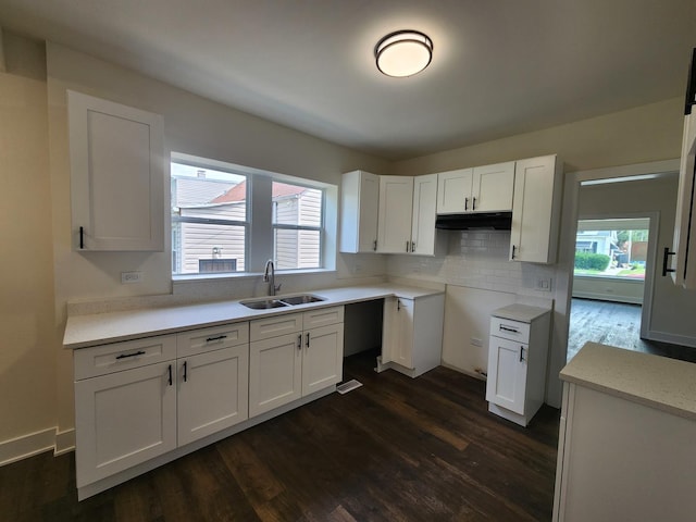 12416 S Carpenter St, Calumet Park, IL 60827 - kitchen with dark wood-style flooring, white cabinets, backsplash, light countertops, and under cabinet range hood
