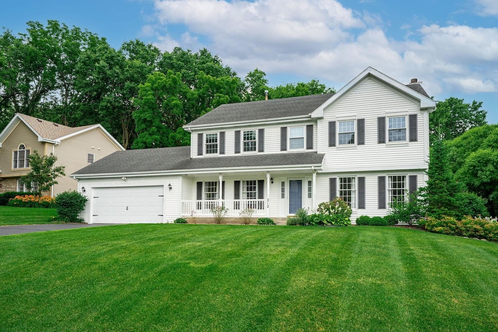 212 Sanctuary Pl, Rockton, IL 61072 - view of front facade with a porch, driveway, a front yard, an attached garage, and roof with shingles