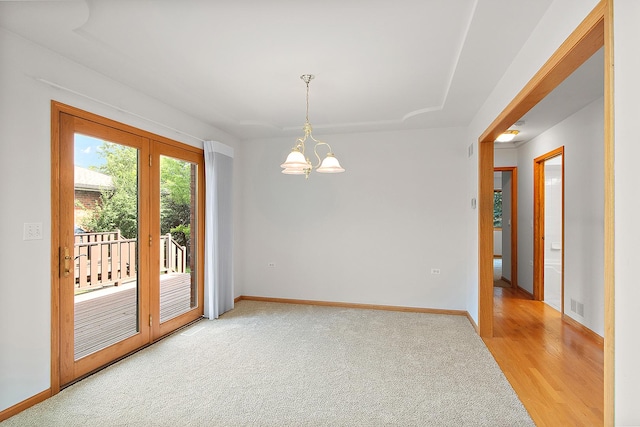 10509 San Luis Ln, Orland Park, IL 60467 - empty room featuring light wood-type flooring, light carpet, and a chandelier