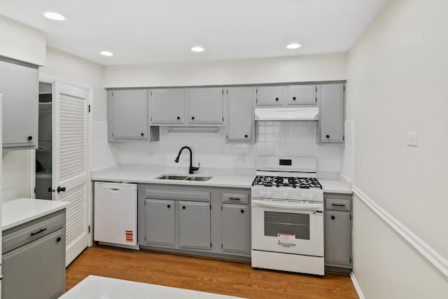7523 Bristol Ln Unit A, Hanover Park, IL 60133 - kitchen with white appliances, gray cabinetry, under cabinet range hood, decorative backsplash, and recessed lighting