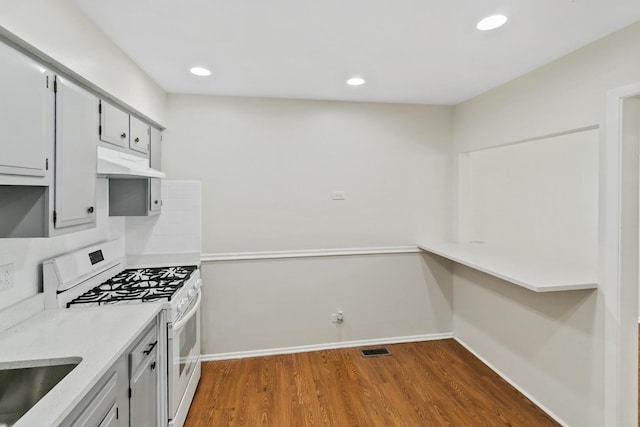 7523 Bristol Ln Unit A, Hanover Park, IL 60133 - kitchen with white range with gas cooktop, under cabinet range hood, dark wood-style floors, light countertops, and recessed lighting