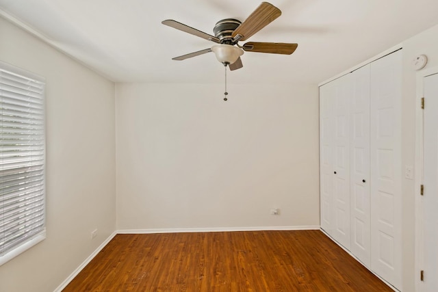 7523 Bristol Ln Unit A, Hanover Park, IL 60133 - unfurnished bedroom with a closet, wood finished floors, multiple windows, and a ceiling fan