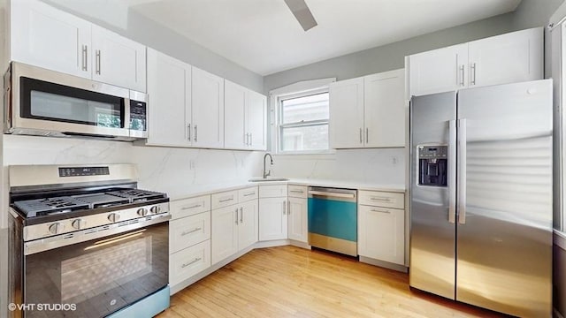 5041 W Fletcher St, Chicago, IL 60641 - kitchen featuring appliances with stainless steel finishes, light countertops, white cabinetry, and light wood-style flooring