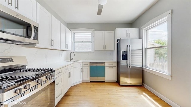 5041 W Fletcher St, Chicago, IL 60641 - kitchen with stainless steel appliances, plenty of natural light, light wood-style flooring, and white cabinets