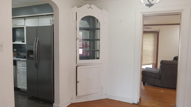 3512 W 84th St, Chicago, IL 60652 - kitchen with stainless steel fridge, arched walkways, dark wood-type flooring, ornamental molding, and white cabinets