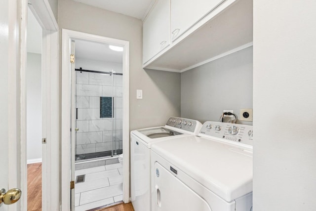 404 Virginia Pl, Wheeling, IL 60090 - washroom with cabinet space, separate washer and dryer, light wood finished floors, and a barn door