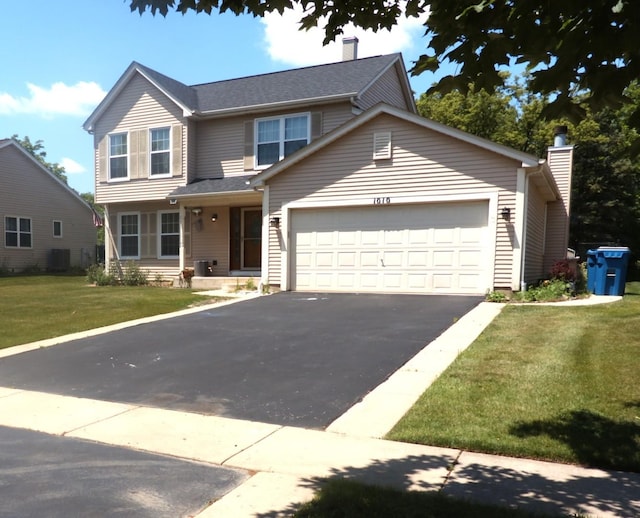 1010 Trillium Ln, Bartlett, IL 60103 - traditional home featuring asphalt driveway, a garage, a front lawn, and a chimney