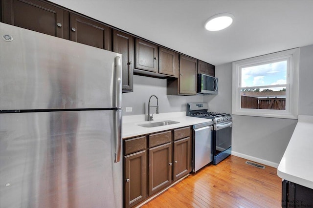 1718 Ardwick Dr, Hoffman Estates, IL 60169 - kitchen with appliances with stainless steel finishes, light countertops, light wood finished floors, and dark brown cabinets