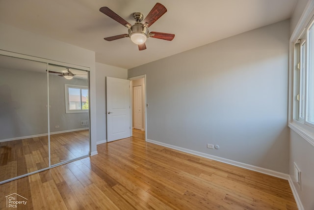 2123 Mallard Ln, Hanover Park, IL 60133 - unfurnished bedroom with multiple windows, light wood-style floors, a closet, and ceiling fan