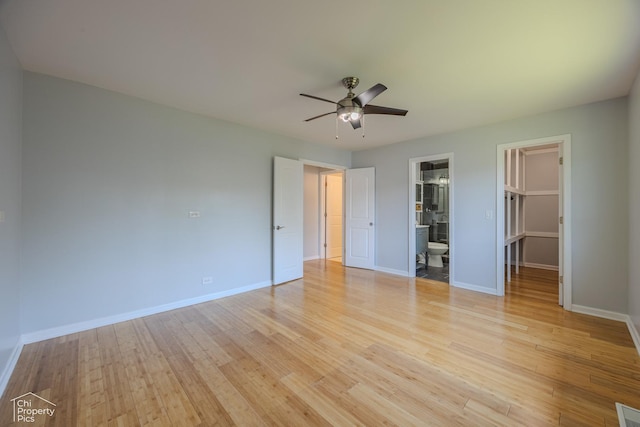2123 Mallard Ln, Hanover Park, IL 60133 - unfurnished bedroom with a walk in closet, light wood finished floors, ceiling fan, and ensuite bath